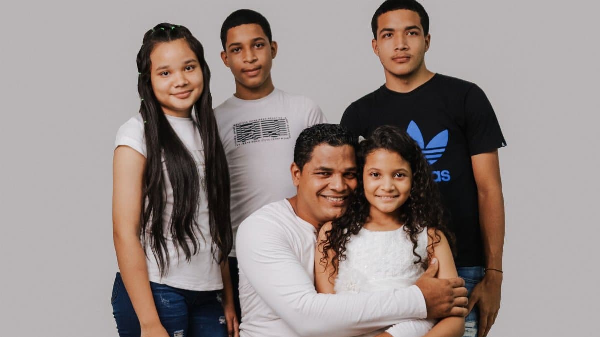 A father with his four children smiling warmly, depicting family love and togetherness.