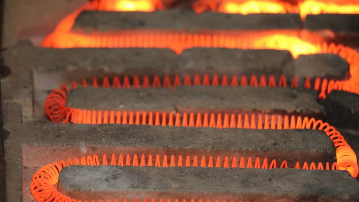 Detailed view of a glowing electric heating element with a coiled structure emitting heat.