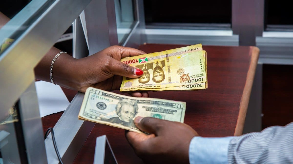 Burundian franc and US dollar exchange transaction at bank counter.