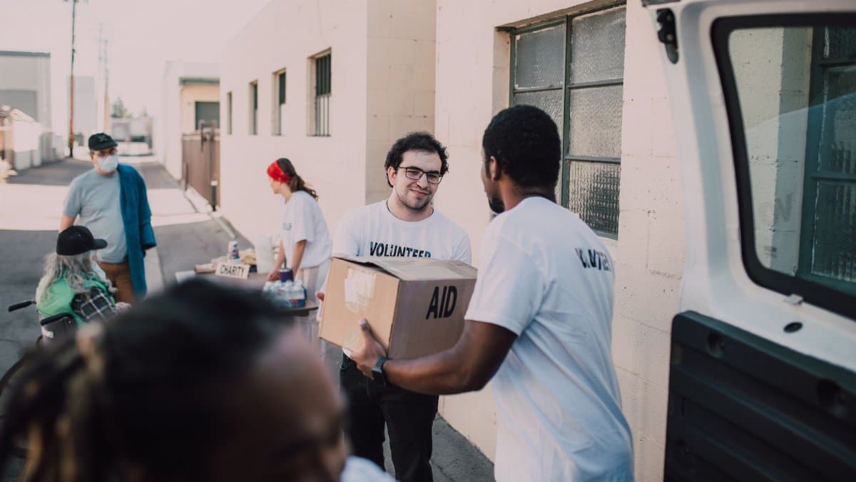 Group of volunteers handing out aid boxes to support community donations.