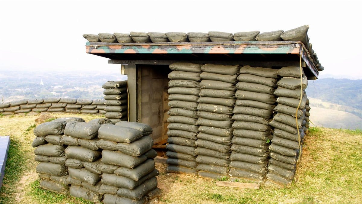 A sandbag bunker structure on a hill, used for military protection.