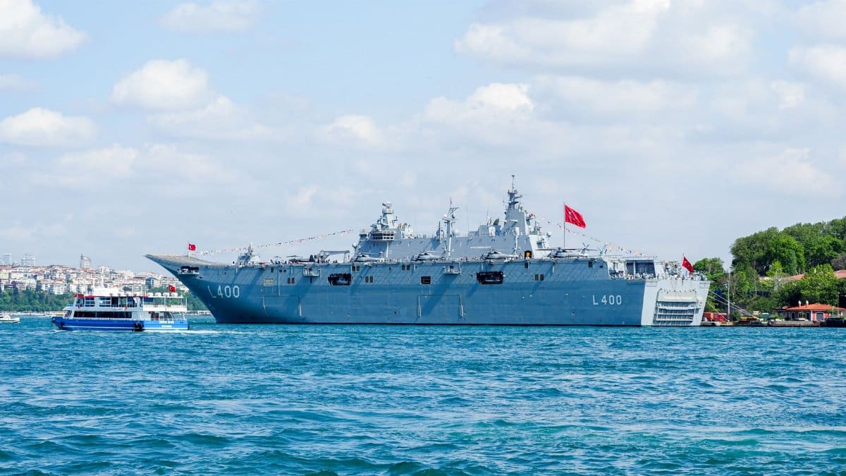Turkish naval warship L400 in the Bosphorus, Istanbul, navigating the strait on a sunny day.