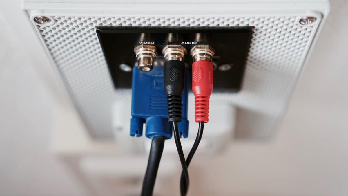 Detailed view of audio and video input cables connected to a wall socket.