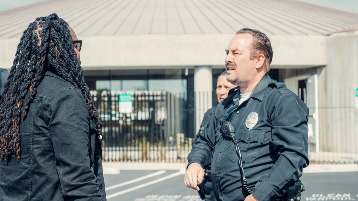 Police officers interacting with a civilian outside a public building, emphasizing community relations.