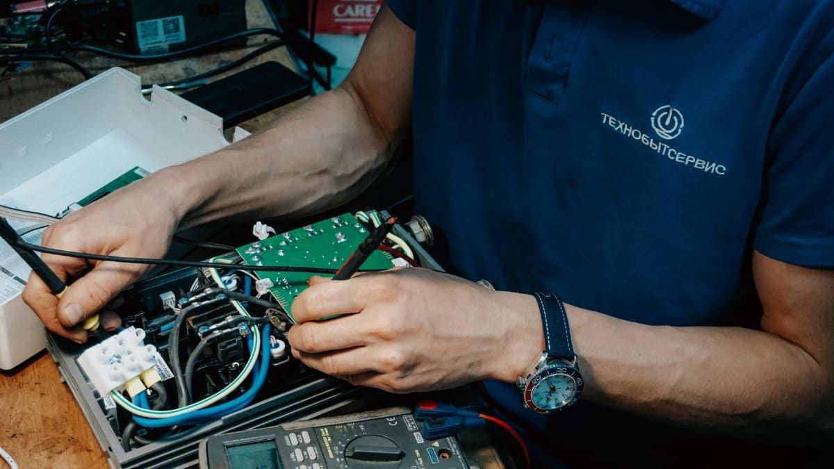 A technician methodically repairs a circuit board, showcasing expertise in electronics and technical skills.