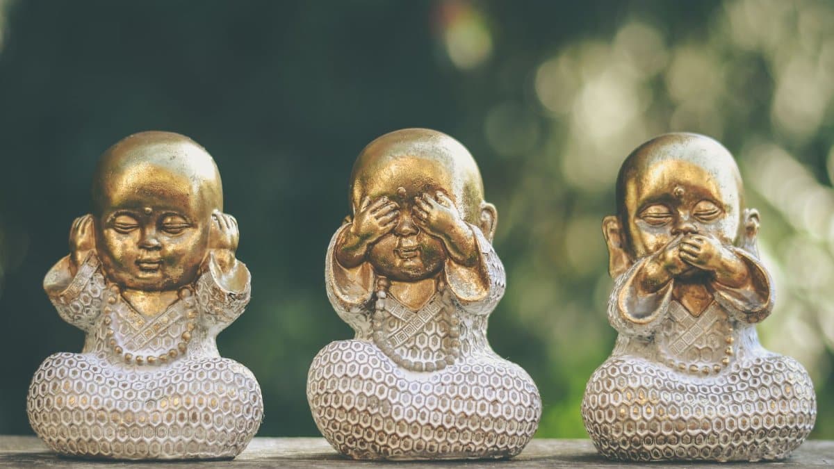 Golden Buddha statues depicting hear no evil, see no evil, speak no evil concept. Perfect for meditation and mindfulness themes.