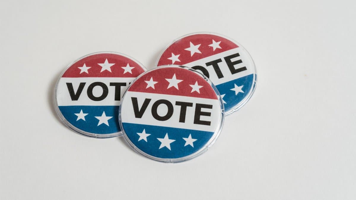 Red, white, and blue voting badges promoting elections on a clean white background.
