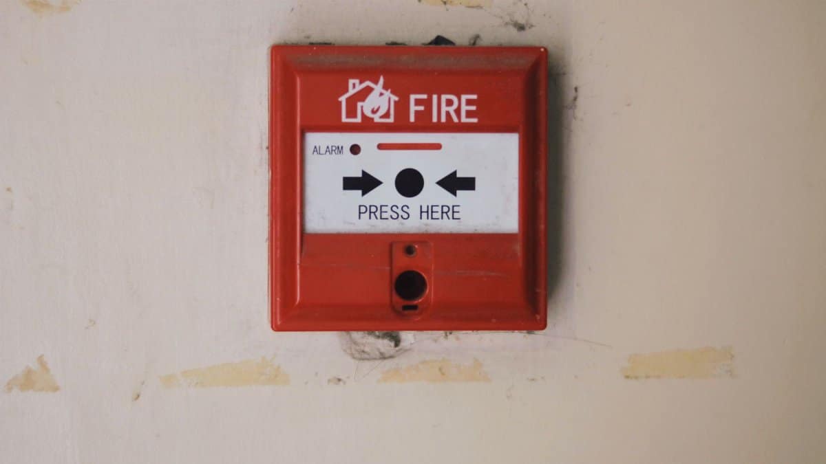 Emergency safety fire detection system box for safety with inscription and push button placed on white wall in light room