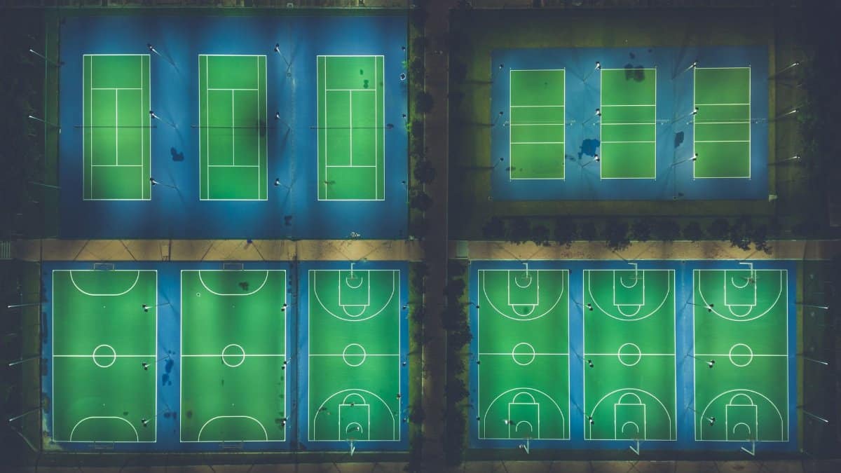 A captivating aerial view of illuminated sports courts at night showcasing patterns and symmetry.