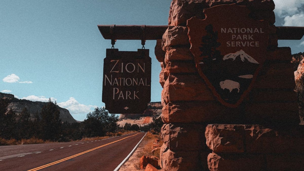 Explore Zion National Park with its iconic entrance sign along a picturesque road in Utah.