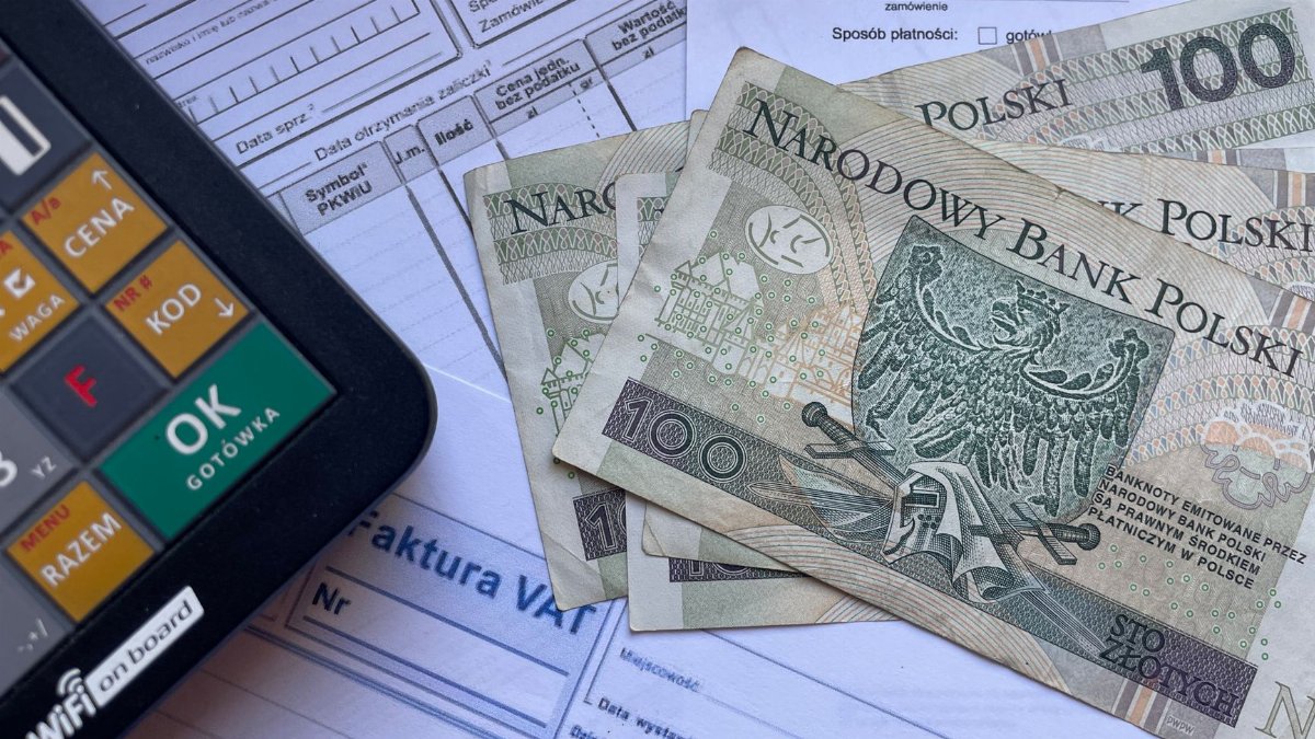 Polish currency placed on invoices with a calculator, illustrating financial transactions or budgeting.