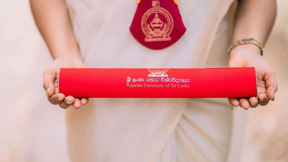 A graduate proudly holds a diploma from Rajarata University of Sri Lanka.