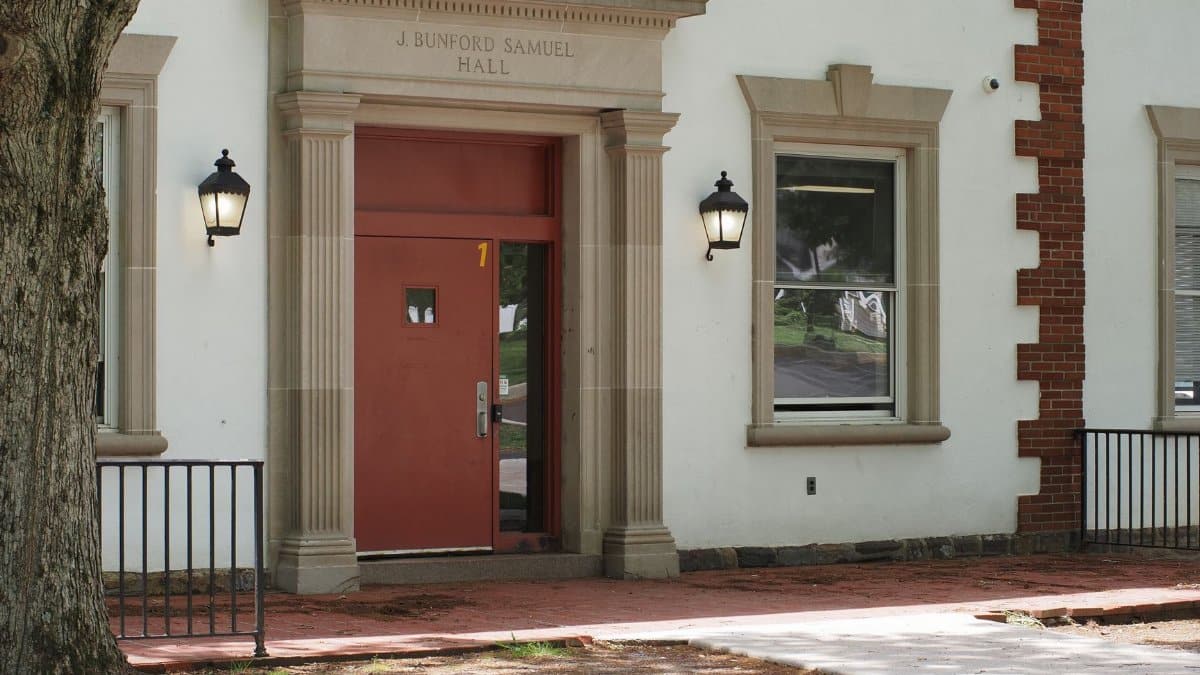 Historic facade of J Bunford Samuel Hall featuring red door and lanterns in Doylestown, Pennsylvania.