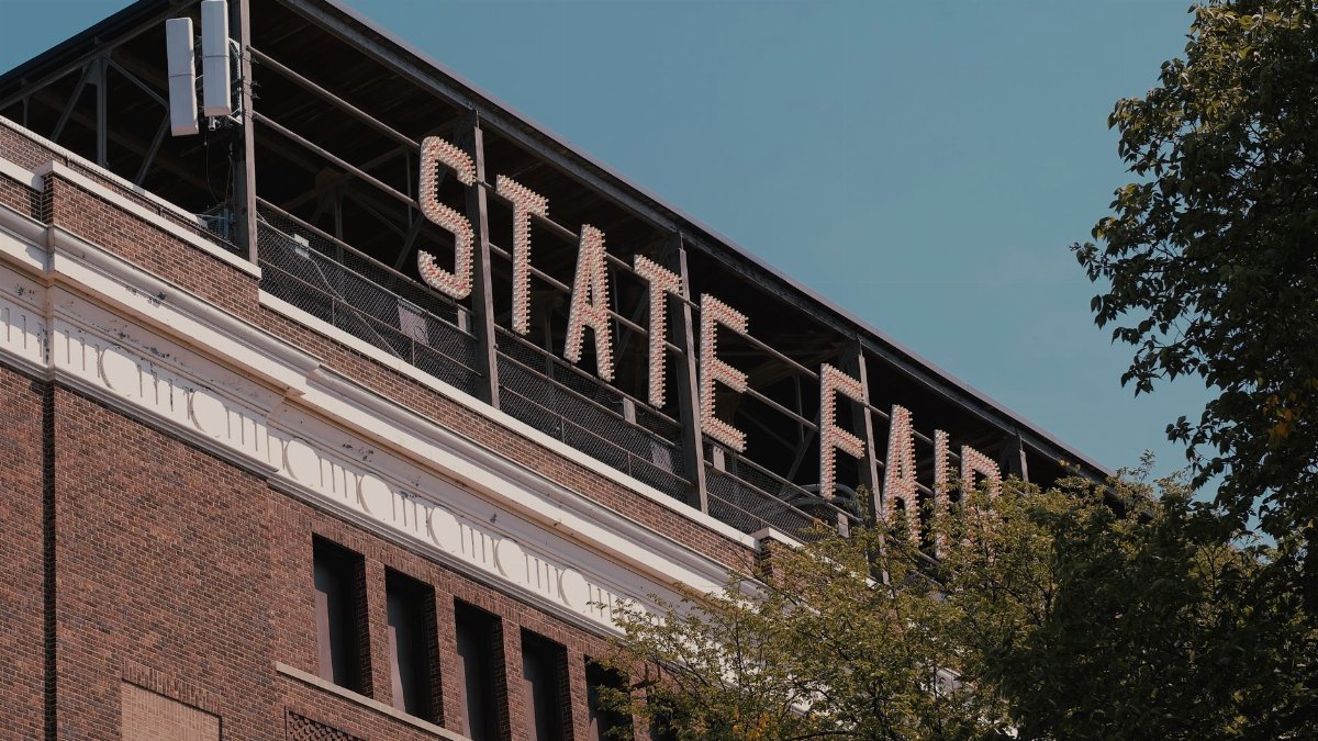 A dramatic view of a State Fair sign on a brick building, captured outdoors during the day.