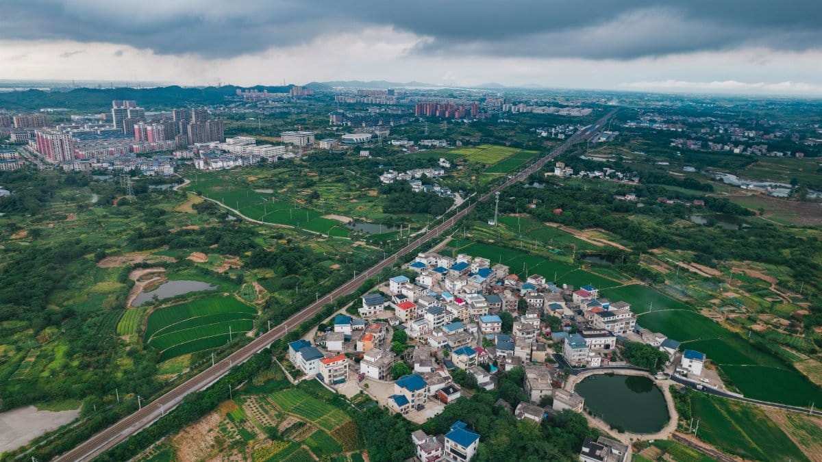 Scenic aerial view of suburban and cityscape areas in Jiujiang, Jiangxi, showcasing urban and rural landscapes.