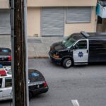 A high angle view of police cars and van on a city street in San Francisco.