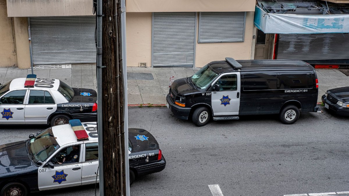 A high angle view of police cars and van on a city street in San Francisco.