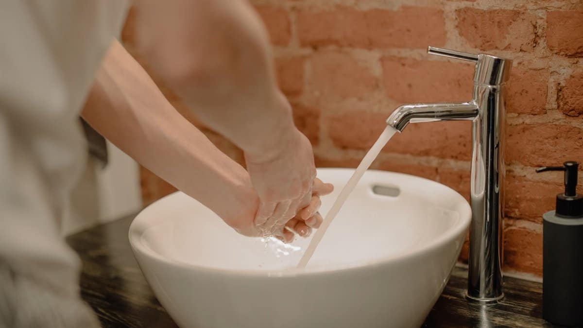 Close-up of hand washing with soap in a stylish bathroom. Vital hygiene practice.