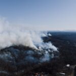 Drone view of a forest wildfire near Rossville, Georgia, USA, smoke rising.
