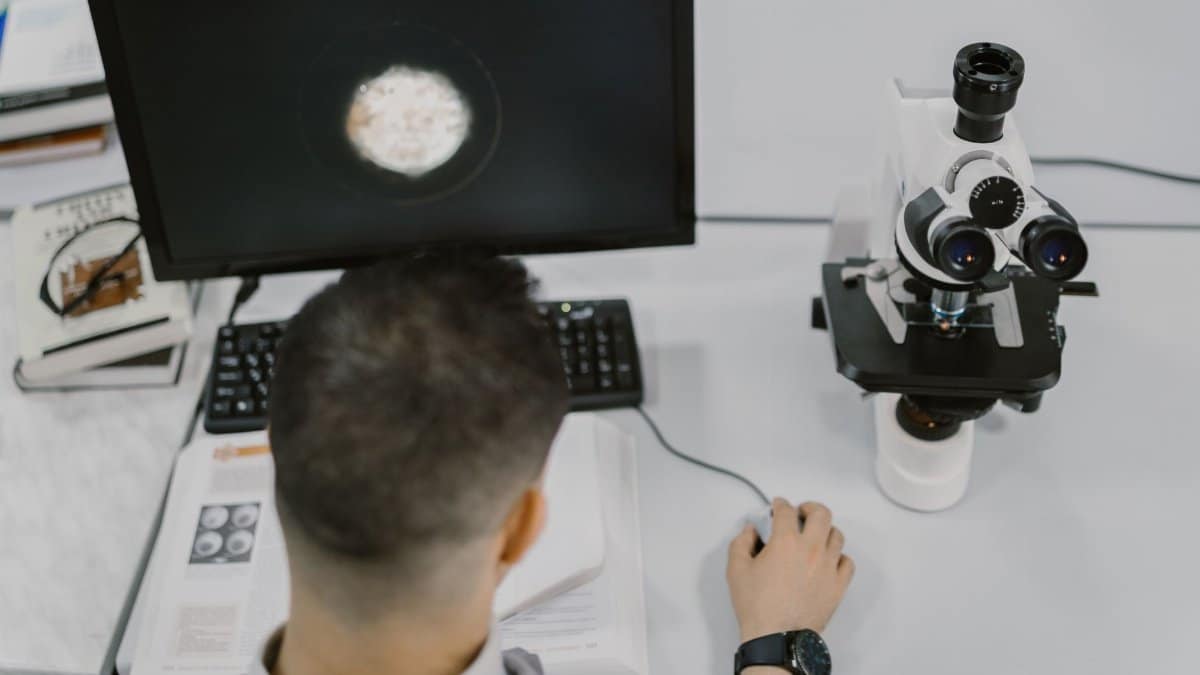 Scientist working with a microscope in a modern laboratory setup.