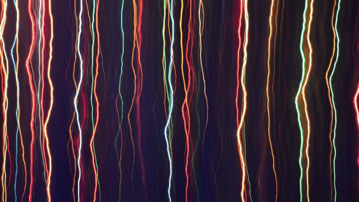 Colorful abstract light streaks against a dark background create a striking visual effect.