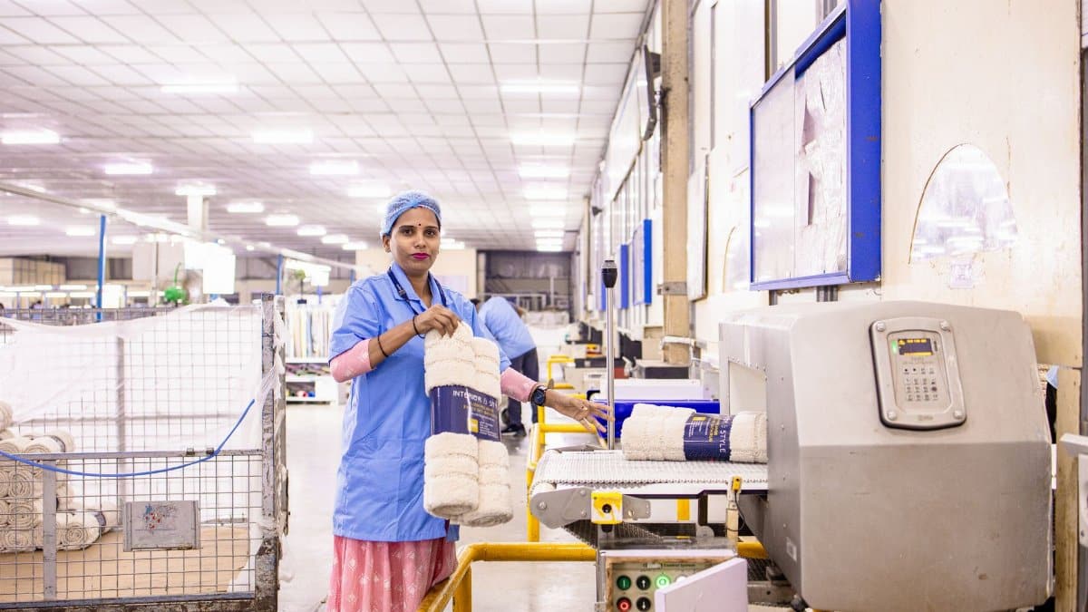 Female textile worker organizing products in a factory setting.