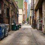 A narrow urban alley in Seattle with trash cans and graffiti, showcasing the city's downtown aesthetic.
