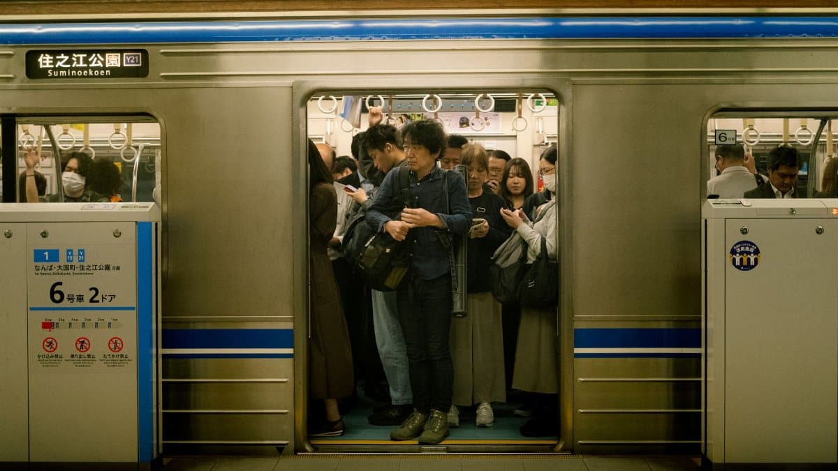 Busy commuters inside a subway train at Suminoekoen Station, Japan. Ideal for urban transport themes.