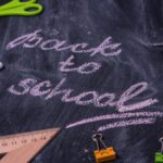 An arrangement of school supplies with 'back to school' written on a chalkboard.