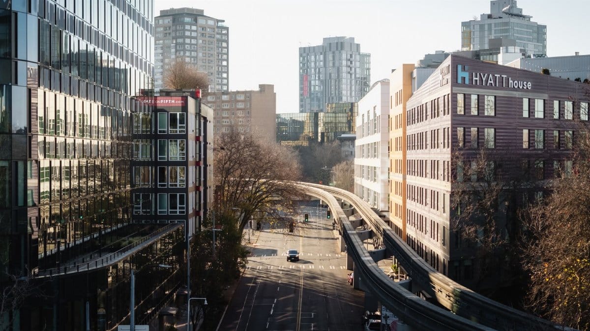 Aerial view of a Seattle city street with modern architecture and monorail tracks.