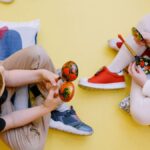 Joyful children playing maracas in a colorful preschool setting.