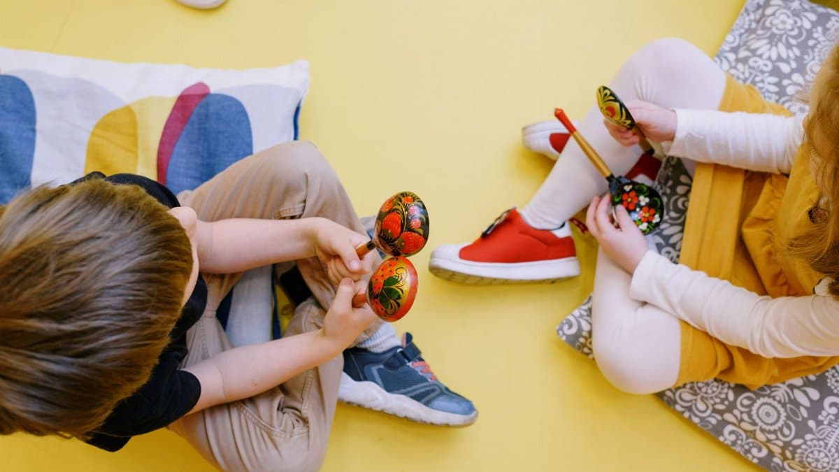 Joyful children playing maracas in a colorful preschool setting.