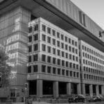 Black and white image of the FBI Headquarters in Washington, D.C. under a clear sky.