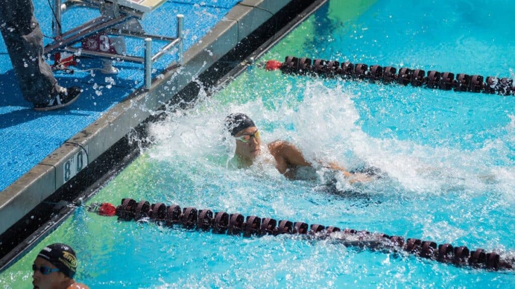 Swimmers compete in an exciting outdoor swimming race, capturing intensity and athleticism.
