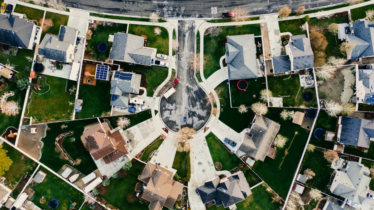 Aerial view showcasing a residential neighborhood in Herriman, Utah with modern architecture and green lawns.
