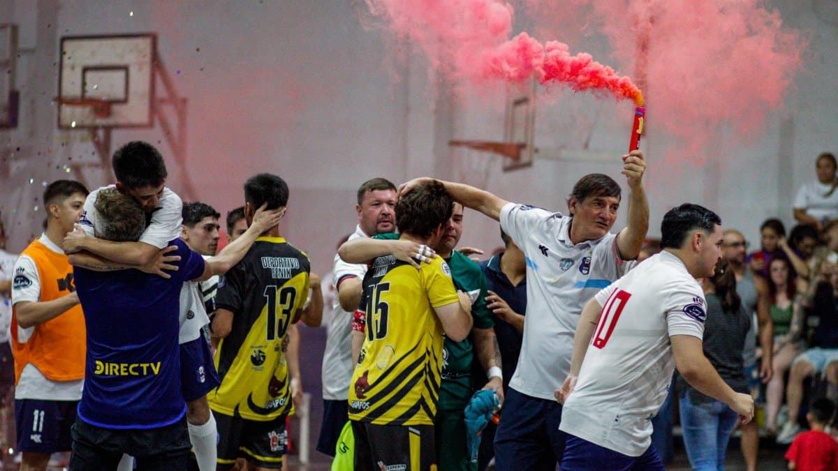 Joyful indoor soccer victory celebration with a vibrant pink smoke flare creating an energetic atmosphere.
