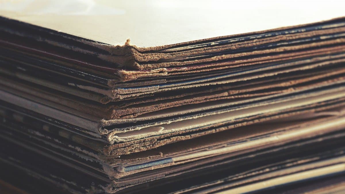Close-up image of stacked vintage cardboard sheets with worn edges.