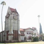 Tower Hall at San Jose State University amid palm trees under a bright summer sky.
