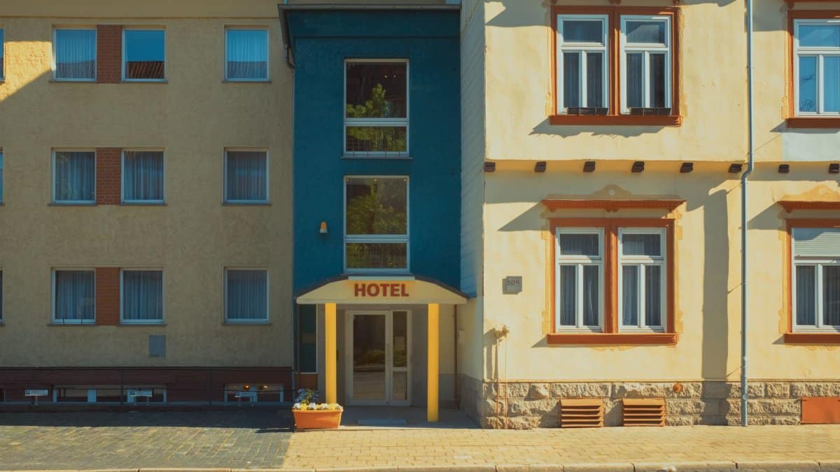 Picturesque facade of a city hotel with warm sunlight and vibrant colors, showing architectural details.