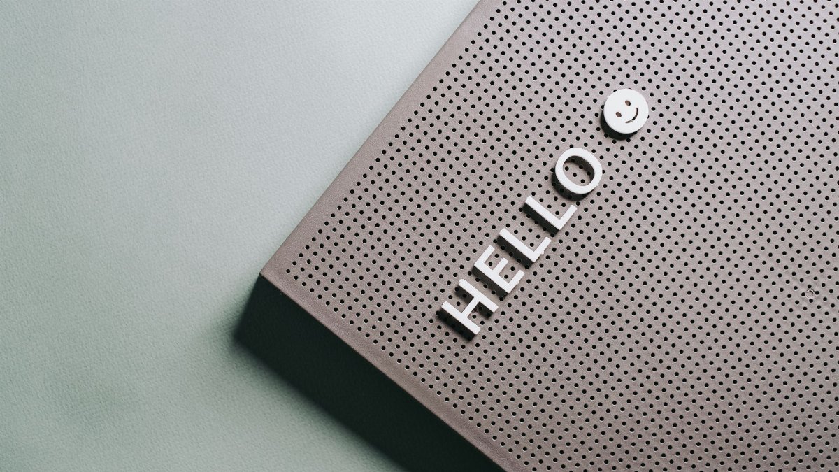 A close-up of a perforated board displaying the text 'HELLO' and a smiley face in a minimalist design.