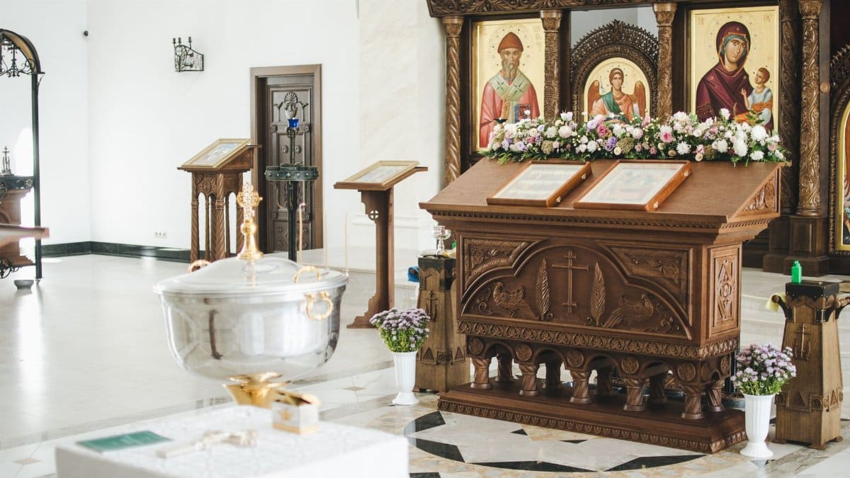 Elegant church interior with religious icons and flower-adorned altar in Minsk, Belarus.