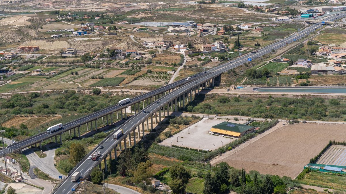 Scenic aerial shot of a highway running through pastoral farmland in Lorca, Murcia, Spain.