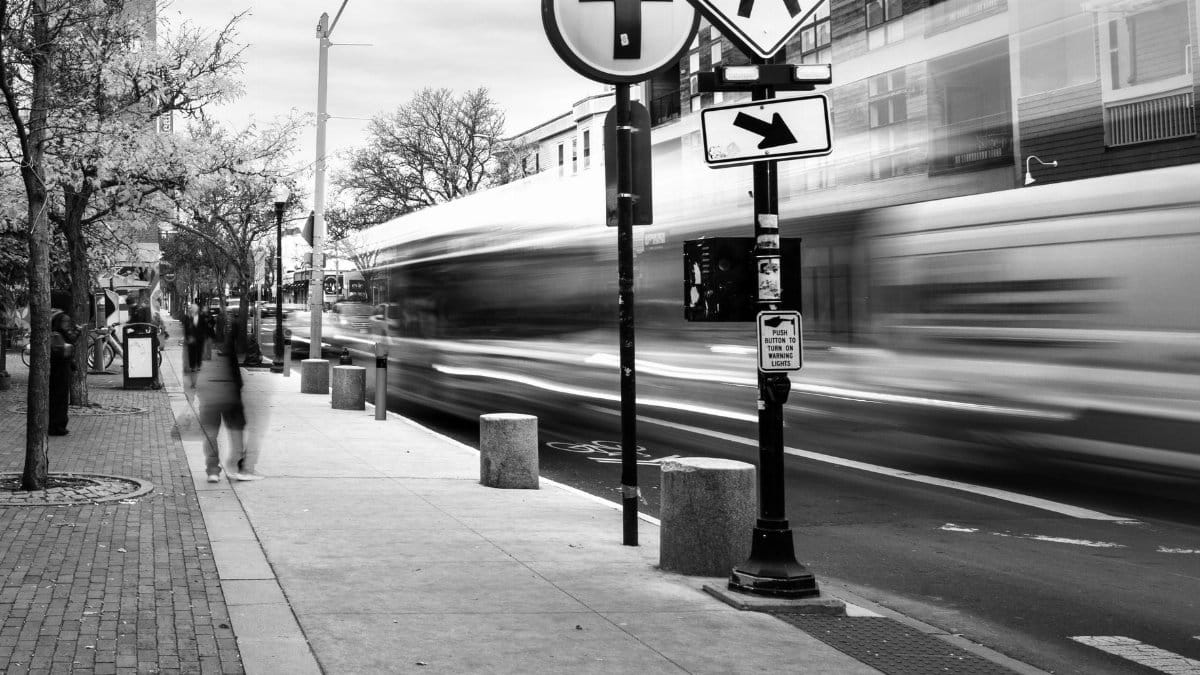 Blurred motion of a city street in Somerville with pedestrians and traffic.
