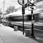 Blurred motion of a city street in Somerville with pedestrians and traffic.