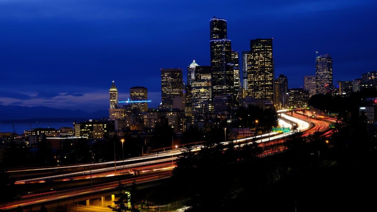Stunning night view of Seattle's skyline with vibrant light trails and city lights creating a dynamic cityscape.