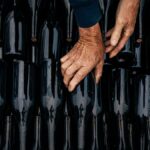 Close-up of hands organizing wine bottles in Nouvelle-Aquitaine's artisanal scene.