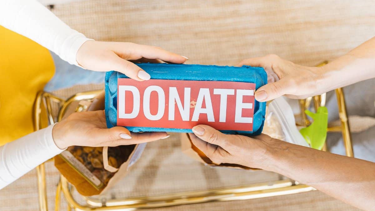 Hands exchanging a donation box filled with items, symbolizing giving and community support.