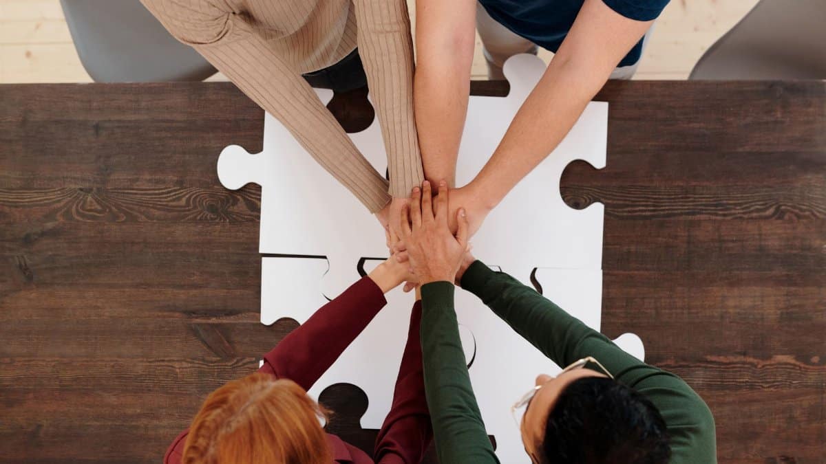 Engaging image of diverse people's hands coming together on puzzle pieces, symbolizing unity.