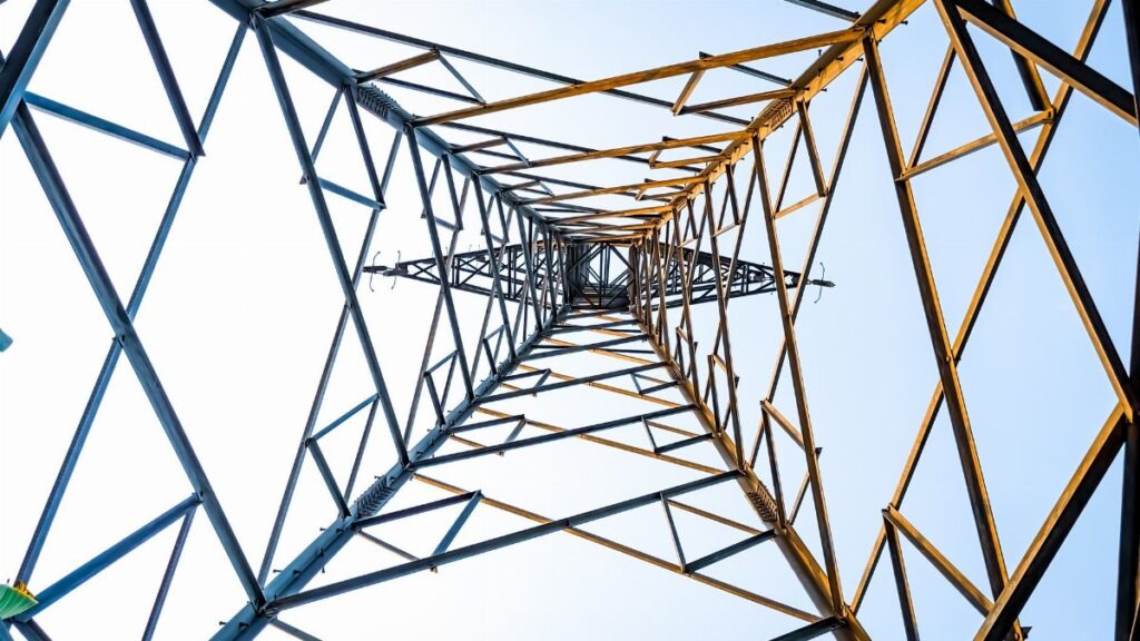 Looking up at a geometric power transmission tower in Depok, Indonesia.