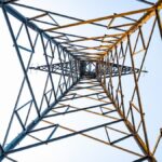 Looking up at a geometric power transmission tower in Depok, Indonesia.